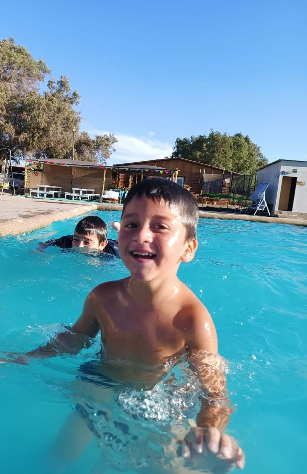 Niños disfrutando de la piscina durante un paseo de curso en Manantial.
